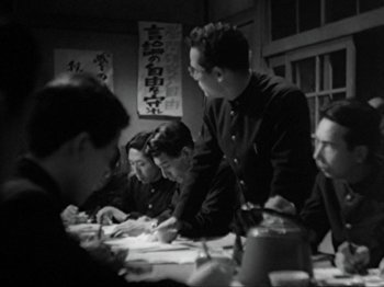 Movie still from “No Regrets for Our Youth” (1946), directed by Akira Kurosawa – A group of people sitting at a table writing; Medium shot, High angle