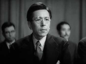 Movie still from “No Regrets for Our Youth” (1946), directed by Akira Kurosawa – An old photo of a man in a suit and tie; Close Up shot, Low angle