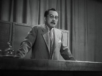 Movie still from “No Regrets for Our Youth” (1946), directed by Akira Kurosawa – An old photo of a man speaking at a podium; Medium shot, Low angle