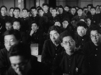 Movie still from “No Regrets for Our Youth” (1946), directed by Akira Kurosawa – Black and white photograph of a group of people in a room; Medium shot, High angle