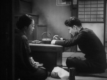 Movie still from “No Regrets for Our Youth” (1946), directed by Akira Kurosawa – A man and a woman sitting at a table in a room; Medium shot, High angle