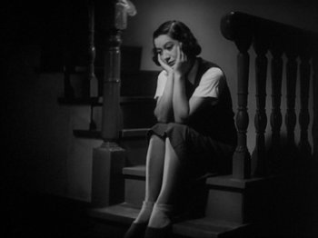 Movie still from “No Regrets for Our Youth” (1946), directed by Akira Kurosawa – A woman sitting on the stairs talking on a phone; Medium shot, High angle