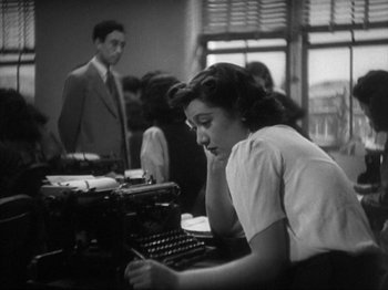 Movie still from “No Regrets for Our Youth” (1946), directed by Akira Kurosawa – A woman sitting in front of an old fashioned typewriter; Medium shot, High angle