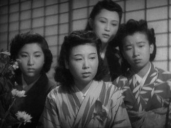 Movie still from “No Regrets for Our Youth” (1946), directed by Akira Kurosawa – A group of young women standing next to each other in front of a brick wall; Medium shot, Low angle