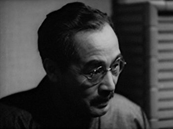 Movie still from “No Regrets for Our Youth” (1946), directed by Akira Kurosawa – An old black and white photo of a man wearing glasses; Close Up shot, Low angle