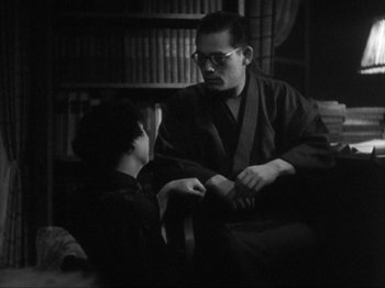Movie still from “No Regrets for Our Youth” (1946), directed by Akira Kurosawa – A man and a woman in a room with a bookshelf in the background; Medium shot, Over the shoulder angle