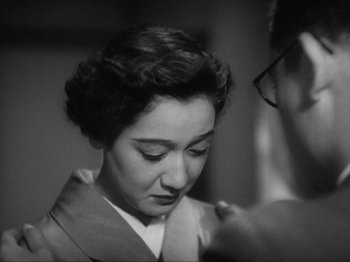 Movie still from “No Regrets for Our Youth” (1946), directed by Akira Kurosawa – An old black and white photo of a woman looking down; Close Up shot, Over the shoulder angle