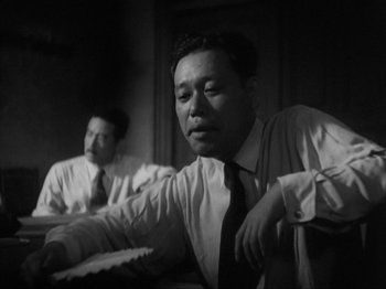 Movie still from “No Regrets for Our Youth” (1946), directed by Akira Kurosawa – Two men in dress clothes sitting in front of a mirror; Medium shot, Low angle