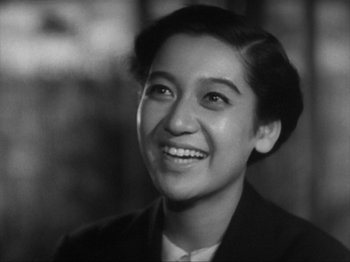 Movie still from “No Regrets for Our Youth” (1946), directed by Akira Kurosawa – Black and white photograph of a young woman smiling; Close Up shot, High angle