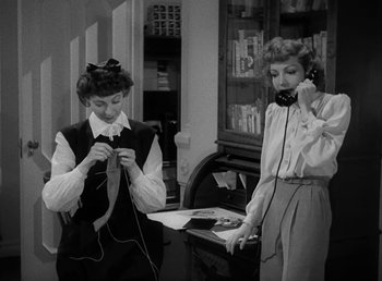 Movie still from “No Time for Love” (1943), directed by Mitchell Leisen – Two women are standing in front of a desk; Medium shot, High angle