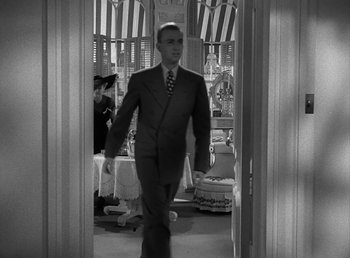 Movie still from “No Time for Love” (1943), directed by Mitchell Leisen – A black and white photo of a man in a suit; Medium shot, Low angle