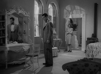 Movie still from “No Time for Love” (1943), directed by Mitchell Leisen – A black and white photo of a man and a woman in a living room; Wide shot, High angle