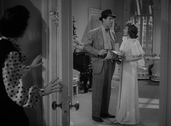 Movie still from “No Time for Love” (1943), directed by Mitchell Leisen – A man and a woman standing next to each other in front of a door; Medium shot, Over the shoulder angle