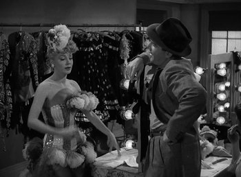 Movie still from “No Time for Love” (1943), directed by Mitchell Leisen – A man and a woman in a costume in front of a mirror; Medium shot, Over the shoulder angle