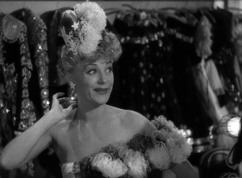 Movie still from “No Time for Love” (1943), directed by Mitchell Leisen – A black - and - white photo of a woman in a dress; Close Up shot, Low angle