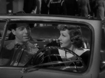 Movie still from “No Time for Love” (1943), directed by Mitchell Leisen – A black and white photo of a man and a woman in the back of a car; Medium shot, High angle