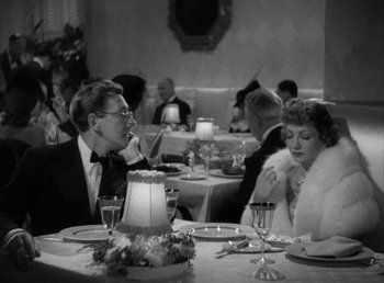 Movie still from “No Time for Love” (1943), directed by Mitchell Leisen – A man and a woman sitting at a dinner table; Medium shot, Over the shoulder angle