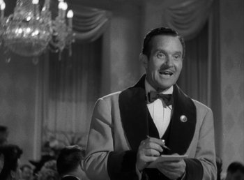 Movie still from “No Time for Love” (1943), directed by Mitchell Leisen – A black and white photo of a man smoking a cigarette; Medium shot, Low angle