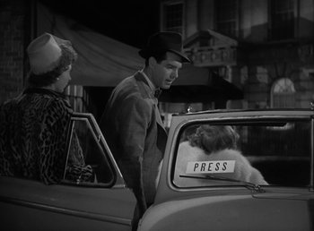 Movie still from “No Time for Love” (1943), directed by Mitchell Leisen – A man and a woman in a car with a dog in the back seat; Medium shot, Over the shoulder angle