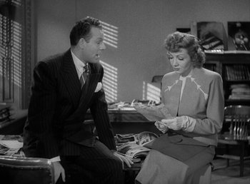 Movie still from “No Time for Love” (1943), directed by Mitchell Leisen – A man and a woman sitting in a room; Medium shot, High angle