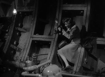 Movie still from “No Time for Love” (1943), directed by Mitchell Leisen – A woman sitting on a chair in a room; Medium shot, Low angle