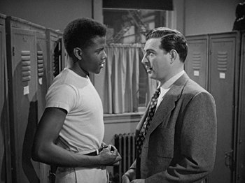 Movie still from “No Way Out” (1950), directed by Joseph L. Mankiewicz – A man and a young man talking to each other; Medium shot, Over the shoulder angle