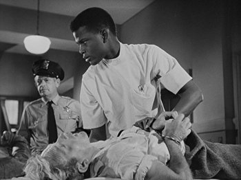 Movie still from “No Way Out” (1950), directed by Joseph L. Mankiewicz – A black and white photo of a man and a woman; Medium shot, Low angle