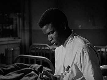 Movie still from “No Way Out” (1950), directed by Joseph L. Mankiewicz – A young man looking at his cell phone in a hospital room; Close Up shot, Low angle
