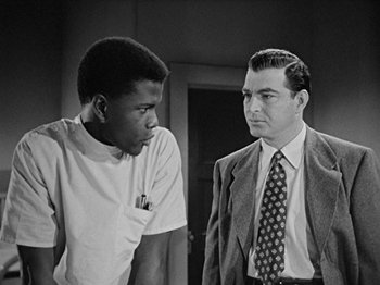 Movie still from “No Way Out” (1950), directed by Joseph L. Mankiewicz – A man and a boy are standing next to each other; Medium shot, Over the shoulder angle