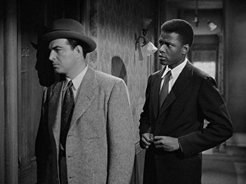 Movie still from “No Way Out” (1950), directed by Joseph L. Mankiewicz – A black and white photo of two men standing next to each other; Medium shot, Over the shoulder angle