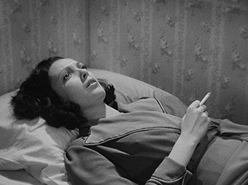 Movie still from “No Way Out” (1950), directed by Joseph L. Mankiewicz – A black and white photo of a woman laying in bed; Medium shot, High angle