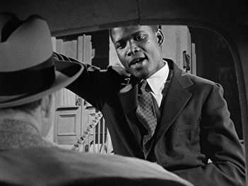 Movie still from “No Way Out” (1950), directed by Joseph L. Mankiewicz – A black and white photo of a man talking on a phone; Close Up shot, Over the shoulder angle