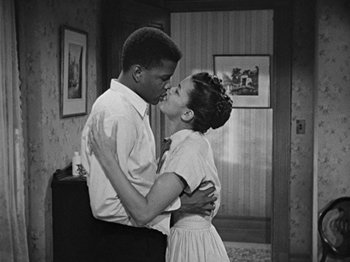 Movie still from “No Way Out” (1950), directed by Joseph L. Mankiewicz – A black and white photo of a man and a woman kissing; Medium shot, High angle