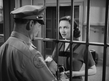 Movie still from “No Way Out” (1950), directed by Joseph L. Mankiewicz – An old photo of a woman talking to a police officer; Medium shot, Over the shoulder angle