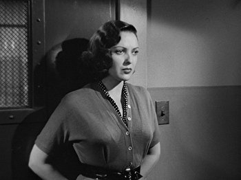 Movie still from “No Way Out” (1950), directed by Joseph L. Mankiewicz – A woman standing in front of a wall; Medium shot, Low angle
