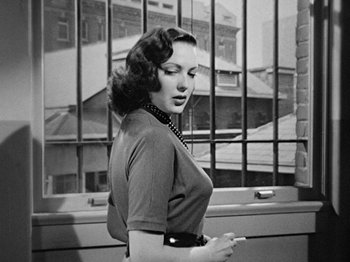 Movie still from “No Way Out” (1950), directed by Joseph L. Mankiewicz – An old photo of a woman smoking a cigarette; Medium shot, Over the shoulder angle