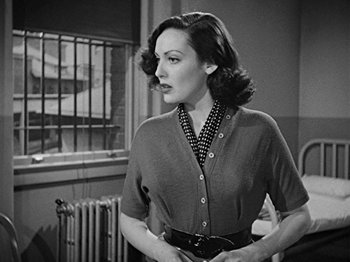 Movie still from “No Way Out” (1950), directed by Joseph L. Mankiewicz – A black - and - white photo of a woman in a dress; Medium shot, Over the shoulder angle