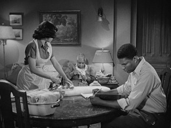 Movie still from “No Way Out” (1950), directed by Joseph L. Mankiewicz – An old black and white photo of a man and a woman cutting cake; Wide shot, High angle