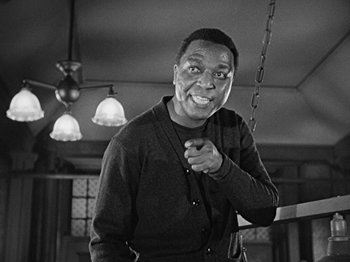 Movie still from “No Way Out” (1950), directed by Joseph L. Mankiewicz – A black and white photo of a man smiling; Medium shot, Low angle