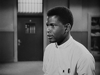 Movie still from “No Way Out” (1950), directed by Joseph L. Mankiewicz – A black and white photo of a man in front of a door; Close Up shot, Low angle