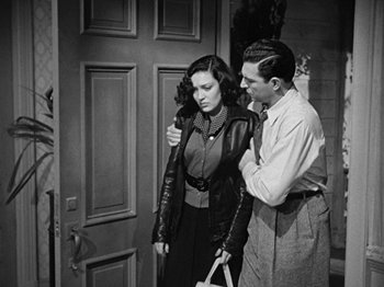 Movie still from “No Way Out” (1950), directed by Joseph L. Mankiewicz – A man and a woman standing next to each other in front of a door; Medium shot, High angle