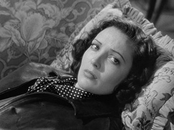 Movie still from “No Way Out” (1950), directed by Joseph L. Mankiewicz – A woman laying on a couch looking at the camera; Close Up shot, High angle