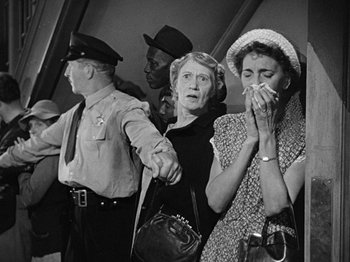 Movie still from “No Way Out” (1950), directed by Joseph L. Mankiewicz – An old black and white photo of a group of people; Medium shot, Over the shoulder angle