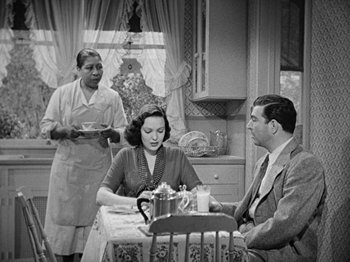Movie still from “No Way Out” (1950), directed by Joseph L. Mankiewicz – An old black and white photo of two women and a man sitting at a table; Medium shot, High angle