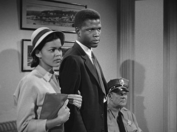 Movie still from “No Way Out” (1950), directed by Joseph L. Mankiewicz – A black and white photo of a man and two women; Medium shot, Low angle