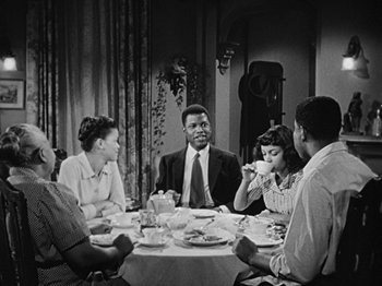 Movie still from “No Way Out” (1950), directed by Joseph L. Mankiewicz – A group of people sitting around a table eating food; Medium shot, High angle