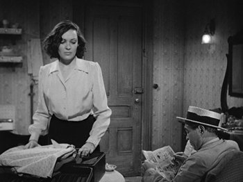 Movie still from “No Way Out” (1950), directed by Joseph L. Mankiewicz – A woman standing in front of a man in front of a door; Medium shot, Over the shoulder angle
