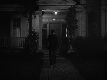 Movie still from “No Way Out” (1950), directed by Joseph L. Mankiewicz – A man walking down a sidewalk at night; Wide shot, Low angle