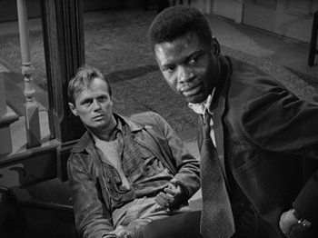 Movie still from “No Way Out” (1950), directed by Joseph L. Mankiewicz – A black and white photo of two men sitting next to each other; Medium shot, Over the shoulder angle