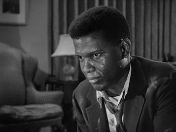 Movie still from “No Way Out” (1950), directed by Joseph L. Mankiewicz – A black and white photo of a man in a suit and tie; Close Up shot, High angle